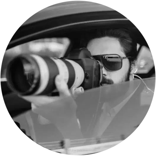 Detective de bajas laborales haciendo fotografías desde un vehículo camufladoo